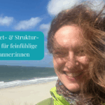 Cornelia mit vom Wind zerzausten Haaren am Meer